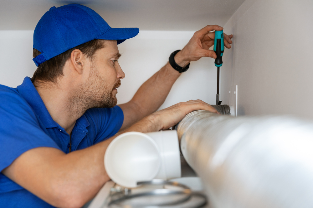 hvac technician repairing flexible aluminum tube for house ventilation system