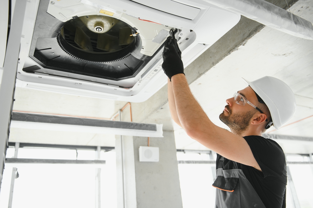 Happy Male Technician Repairing Air Conditioner.